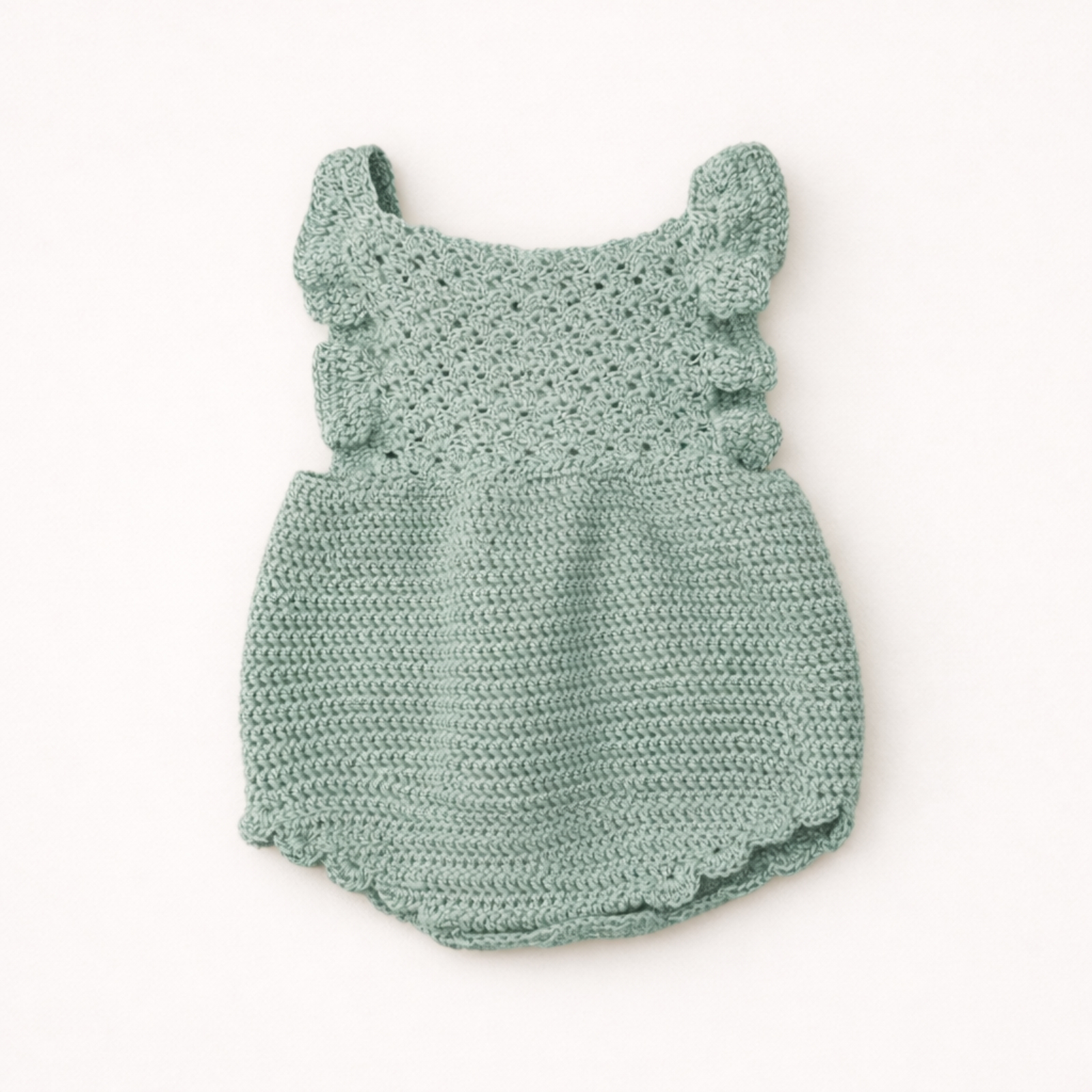 Handmade crochet baby romper in soft blue color on a neutral background